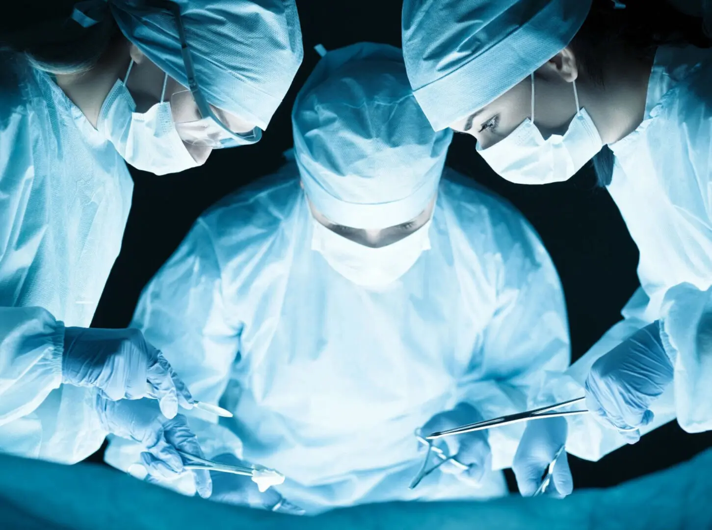 A close up picture of three surgeons doing an operation